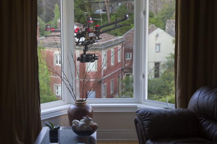A drone with a camera hovering outside living-room window.