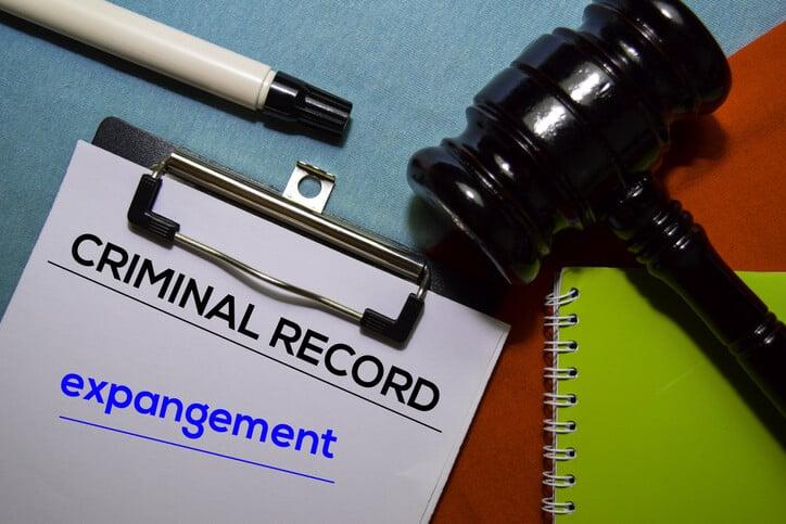Criminal Record and Expangement text on Document form and Gavel isolated on office desk.