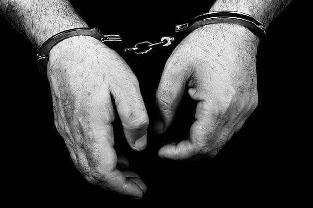 Black and white picture of a prisoner with cuffs