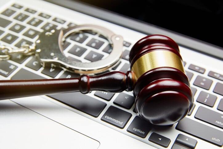 HANDCUFFS AND GAVEL ON COMPUTER KEYBOARD